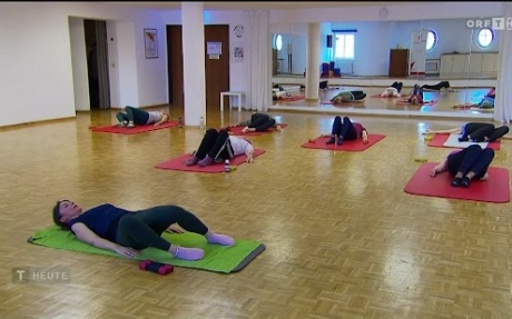 Mehrere Menschen machen Yoga auf Matten