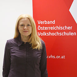Susanne Beier vor der Fotowand des Verband Österreichische Volkshochschulen